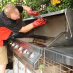 Man in rubber gloves cleaning a bbq