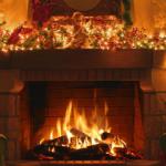 A roaring fire with christmas decorations around the mantelpiece