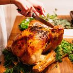 A woman carving a roast turkey