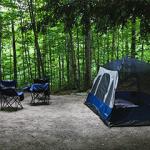 A tent and camping chairs in a forrest