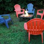 Blue and red chairs around an outdoor fire