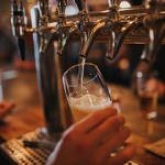 Person pulling a pint at a bar