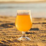 A pint of beer on a sandy beach